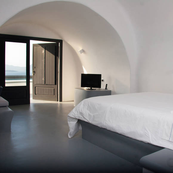 Grand Ambassador Santorini Superior Deluxe Room bedroom with Cycladic vaulted ceiling, double bed, and sea view terrace