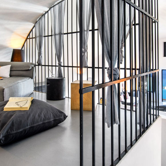 Loft suite interior at Grand Ambassador with modern furniture, reading nook, and ocean view through large windows